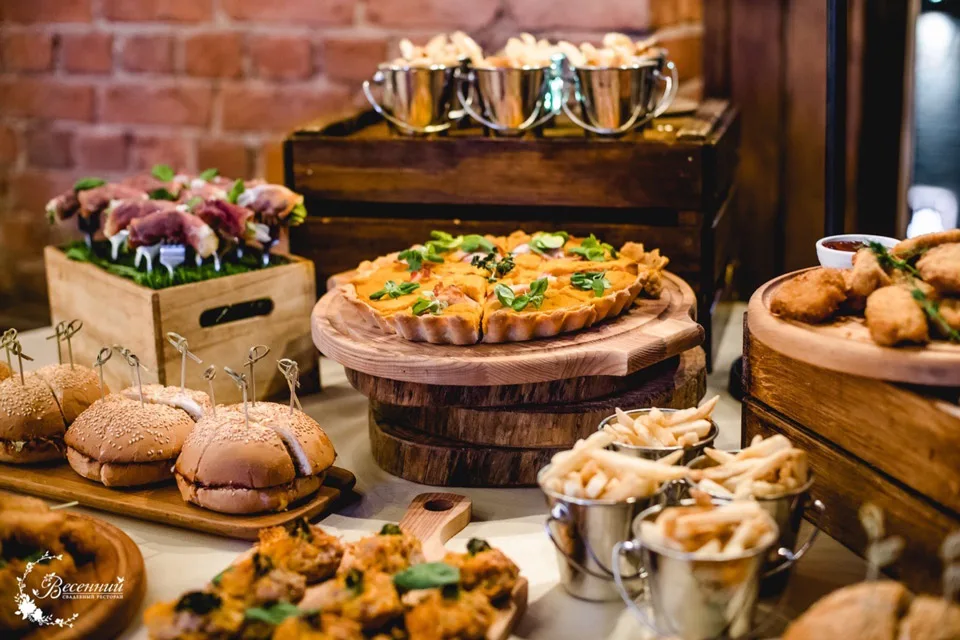 Пакет «Мясной пир» — фуршетный стол с пиццей и мясными закусками у кирпичной стены