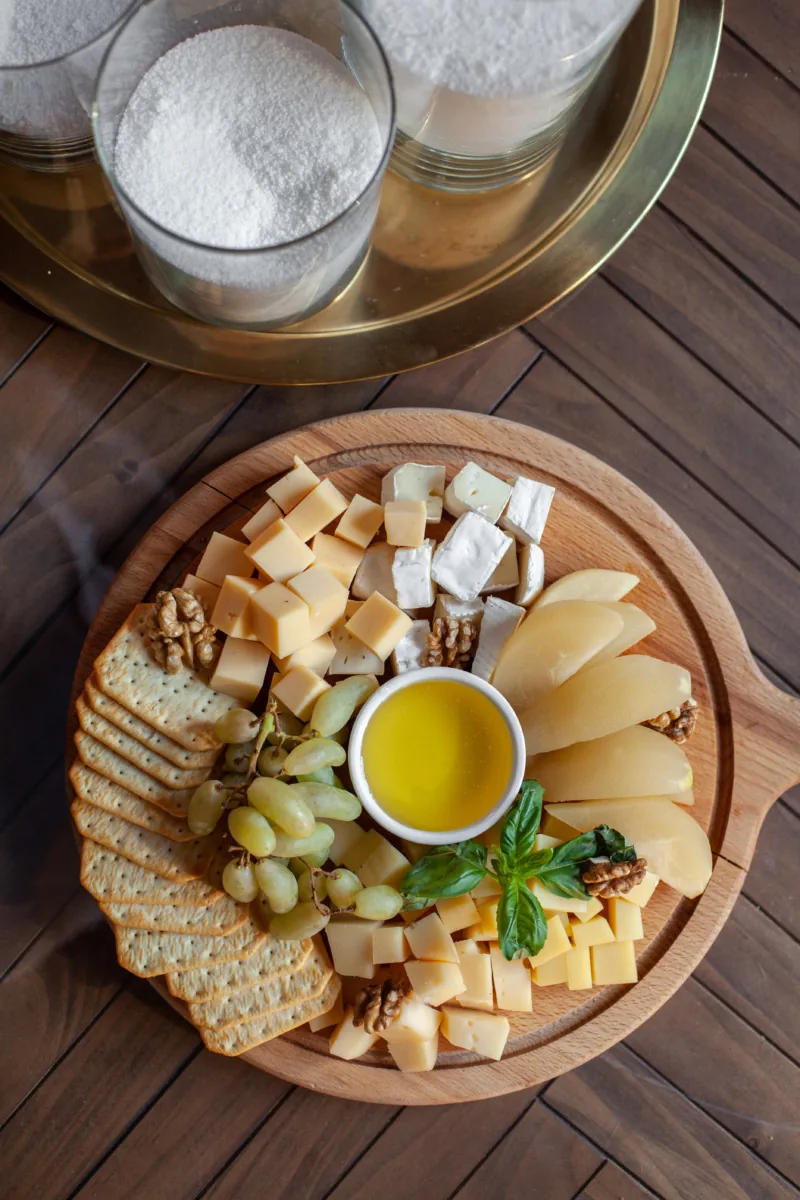 Сырная тарелка с виноградом, мёдом и крекерами